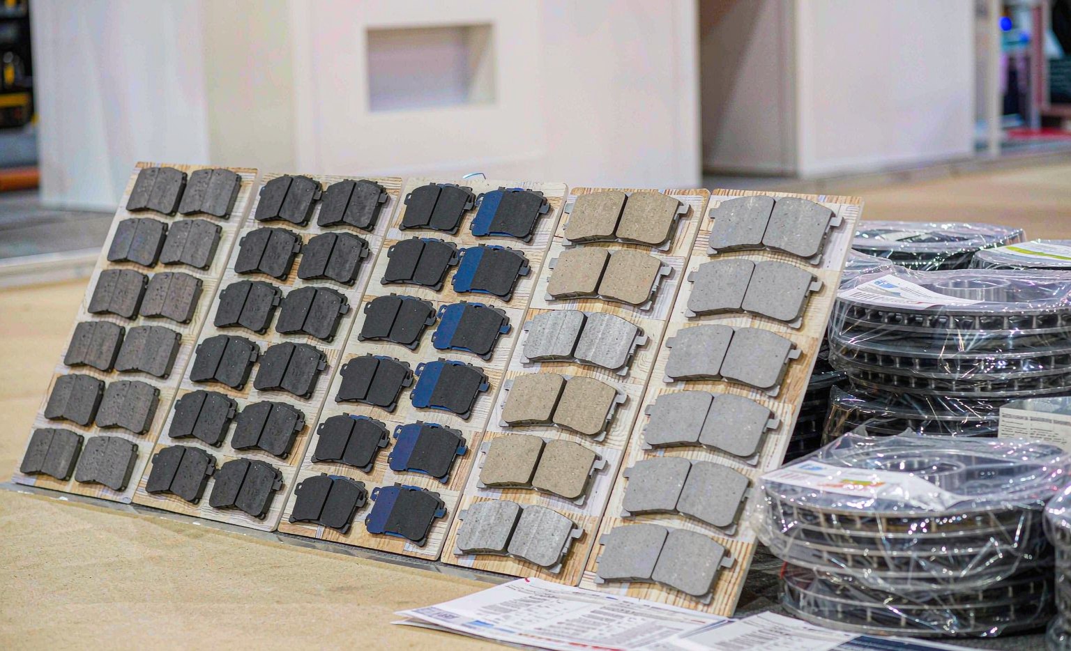 Brake pads, rotors and calipers laid out as samples on a trade show booth display table for wholesale buyers