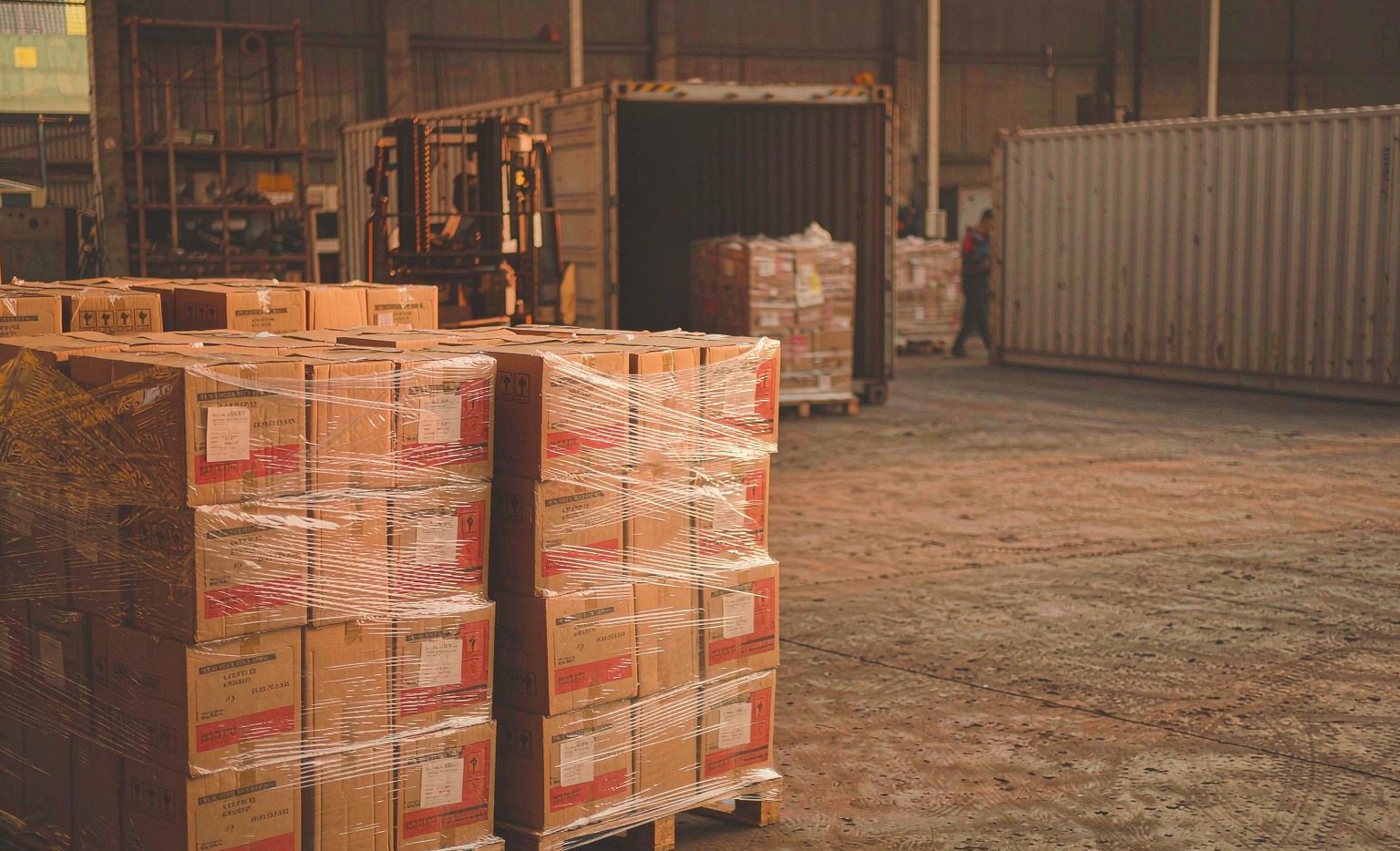 Toyota RAV4 cooling and engine parts cardboard boxes stacked and shrink-wrapped on a wooden pallet at a Chinese export yard, ready for 40HQ container loading
